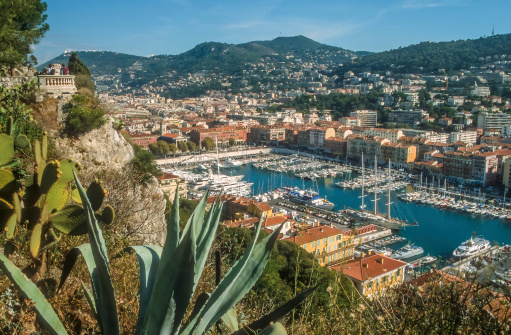 Rows of yachts in marina of Menton, old town is seen in the background, aerial view, Cote d'Azur, French Riviera, France, Europe.