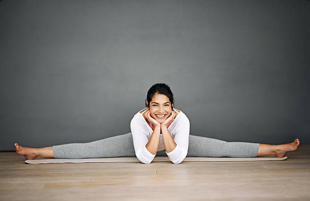 yoga ist der beste start in den tag - the splits ethnic women exercising stock-fotos und bilder