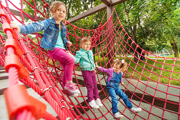 istock Three small girl sitting on red grid in summer 507881365