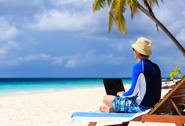 istock man with laptop on tropical vacation 507881861