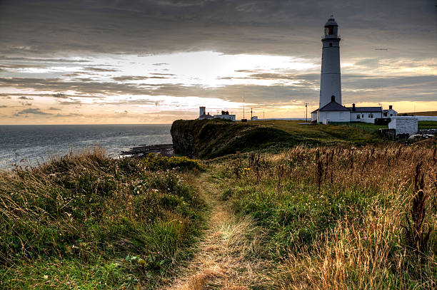 istock White lighthouse against dark sky at sunset 507896593