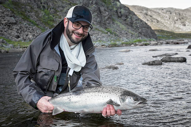 istock fisherman holding fresh caught salmon 507898495
