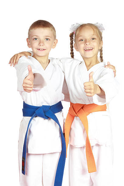 非常にハッピーな少年と少女のアスリート karategi - thumbs up child success winning ストックフォトと画像