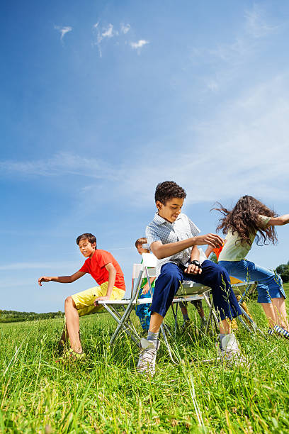 istock Kids playing game and sit fast on chairs outside 507899371