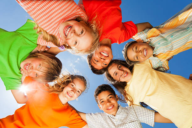 istock Happy children close in circle on sky background 507899387