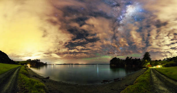 Milky Way shining bright at night Milky Way, clouds and green airglow shining bright over Scandretts Bay, New Zealand stars in your eyes stock pictures, royalty-free photos & images