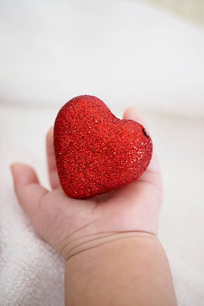 istock Baby's hand hold a heart 507902130