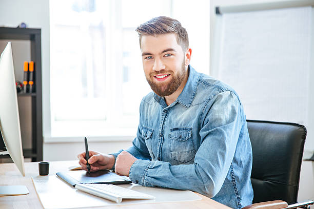 istock Happy designer working using pen tablet with stylus in office 507902766