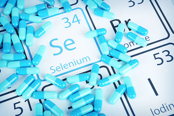 Selenium - Mineral Supplement on Periodic Table Selenium with capsules or pills on the periodic table (Periodic table made by me) Stock image representing mineral supplementation. vitamins and minerals chart stock pictures, royalty-free photos & images