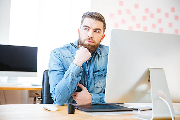 istock Pensive modern designer sitting on workplace and thinking 507903010