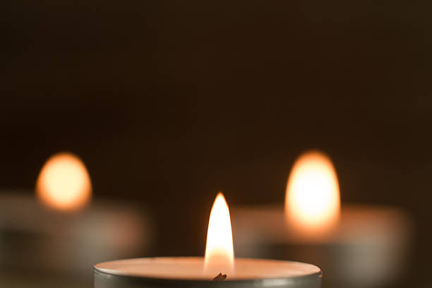 istock light  burning brightly candles on old wooden background. 507903346