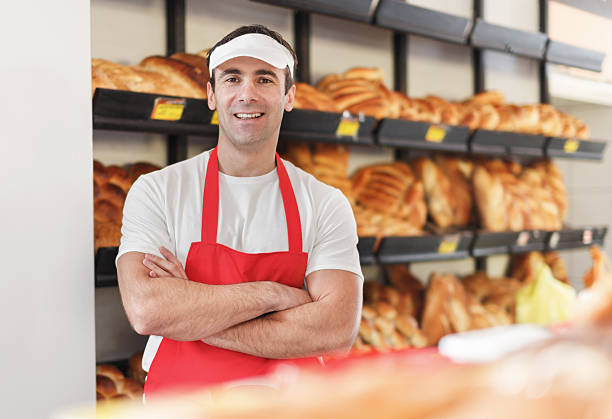 istock Happy male baker with arms crossed looking at camera. 507904854