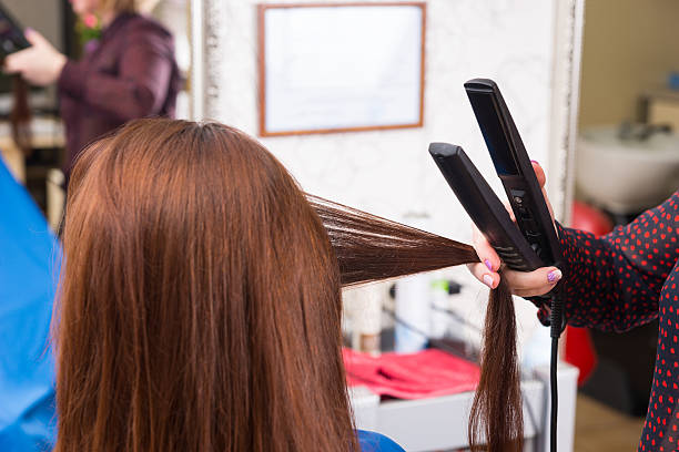 istock Stylist Using Flat Iron on Hair of Brunette Client 507904858