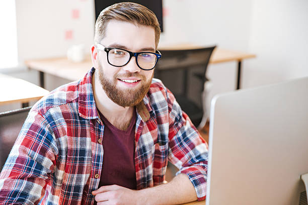 istock Happy handsome young man sitting and working with computer 507905042