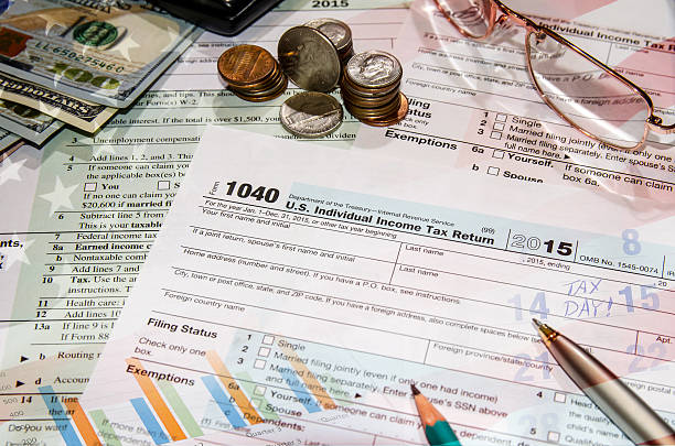 istock 1040 tax form with dollar, glasses, calculator, notepad 507905654