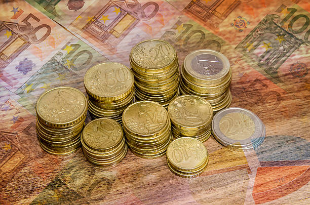istock different  golden euro coins on wooden table background 507905762