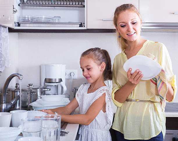 istock girls doing and wiping dishes in kitchen 507906868