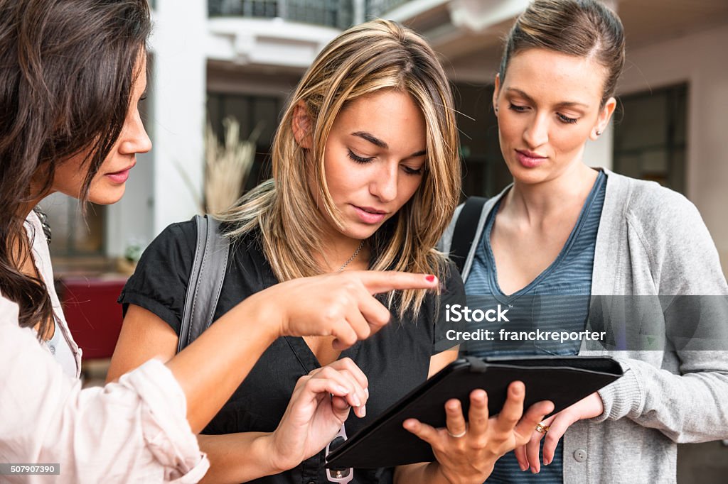 Group of friends using a tablet at the university 20-29 Years Stock Photo