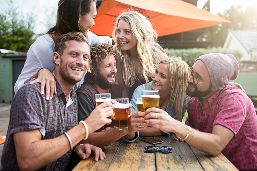 Australian friends having drinks on a terrace bar.