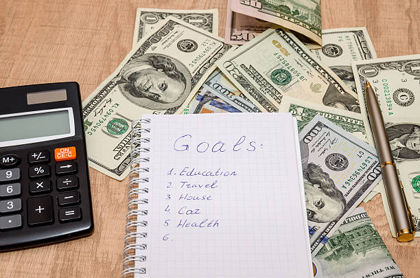 istock Financial goal concept, word on notepad with dollar bills, glass 507909748
