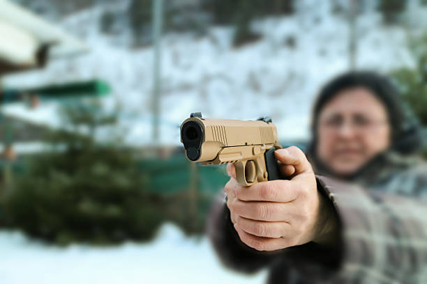 istock Woman shooting outdoor with a gun,  selective focus 507910466