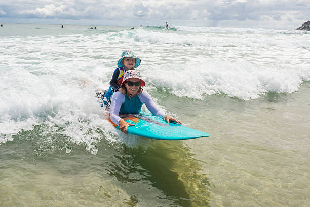 istock Mother Taking Her Young Child Surfing at the Beach 507912516
