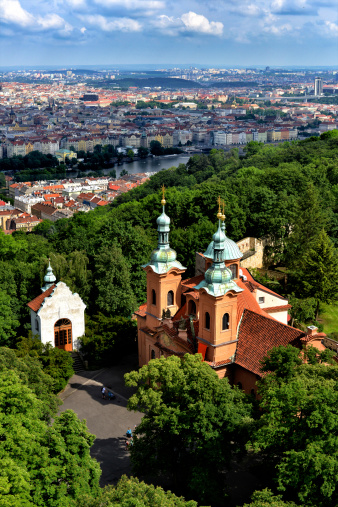 The beautiful Old Town section of Prague as seen from a downscaled version of the Eiffel Tower on Petrin Hill. In the foreground is St. Lawrence Church.