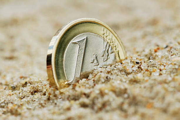 istock Euro coin on sand. 507920113