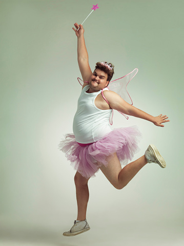 An overweight man comically dressed-up in a pink fairy costume