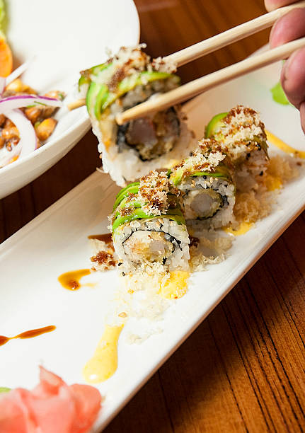 istock Eating Gourmet Sushi California Roll With Chopsticks 507923809