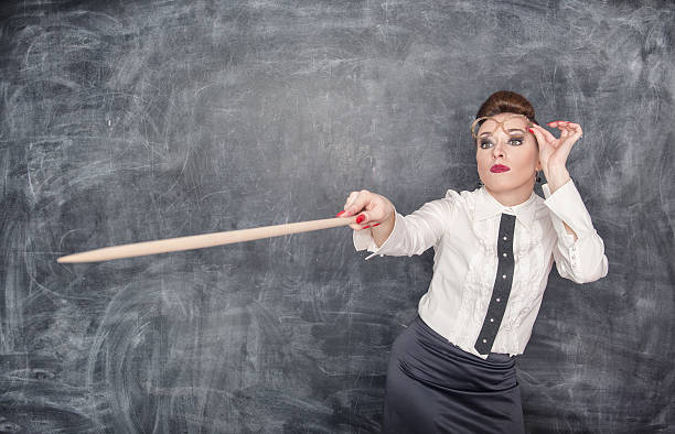 istock Strict teacher showing on something by wooden pointer 507953377
