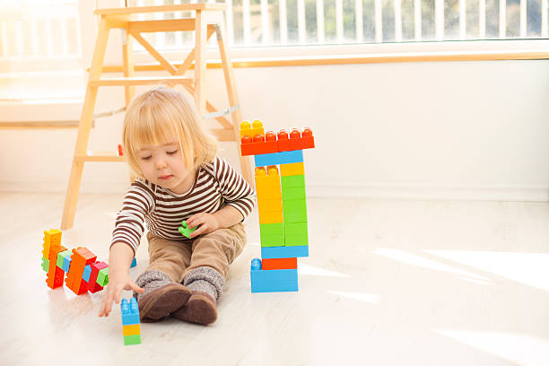 istock Little blond boy playing with colorful plastic blocks 507955620
