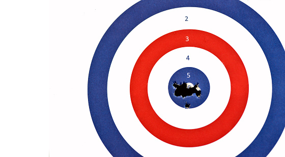 A traditional paper airrifle terget shot through the centre Bullseye after an afternoon at the shooting range