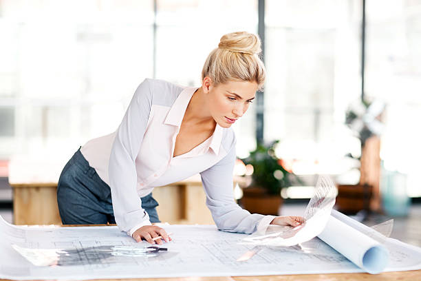 istock Architect Examining Blueprint At Desk 507958213