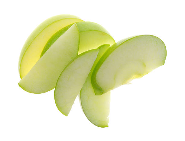 Green apple slices on white background top view Top view of a group of green apple slices isolated on a white background. green apple slice stock pictures, royalty-free photos & images