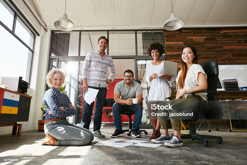 Team of creative people in office Portrait of happy young people in a meeting looking at camera and smiling. Young designers working together on a creative project. Teamwork Stock Photo