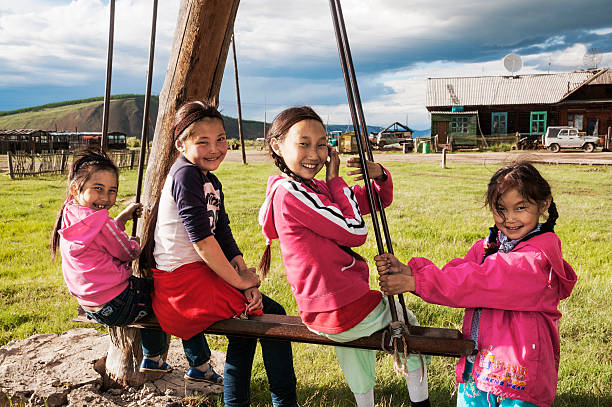 School-age girls on a swing stock photo