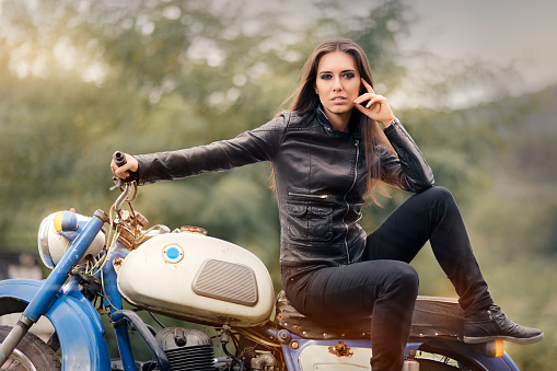 Portrait of a cool woman on a vintage motorbike 