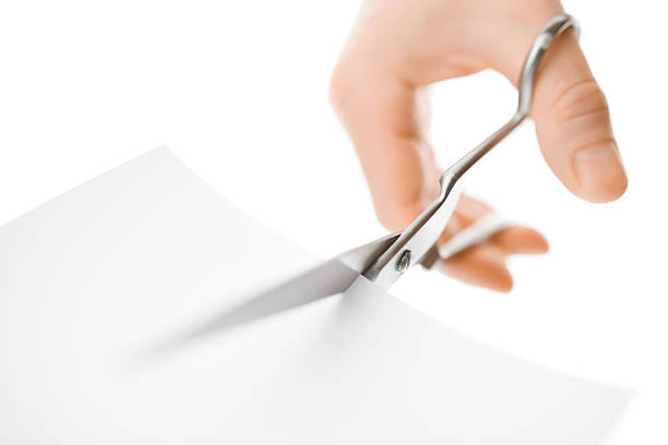 istock Hand with scissors cutting a white sheet of paper 507969036