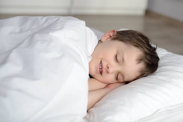 istock Cute child is sleeping in white bed 507970836