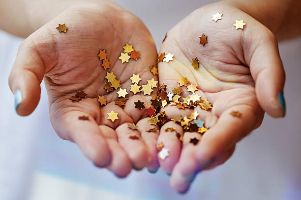 istock Girl holding gold star confetti 507972486