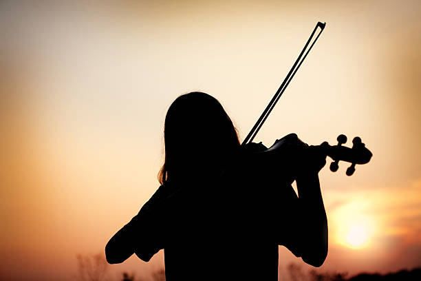 istock Silhouette Of Child Playing Viola At Sunset 507983991