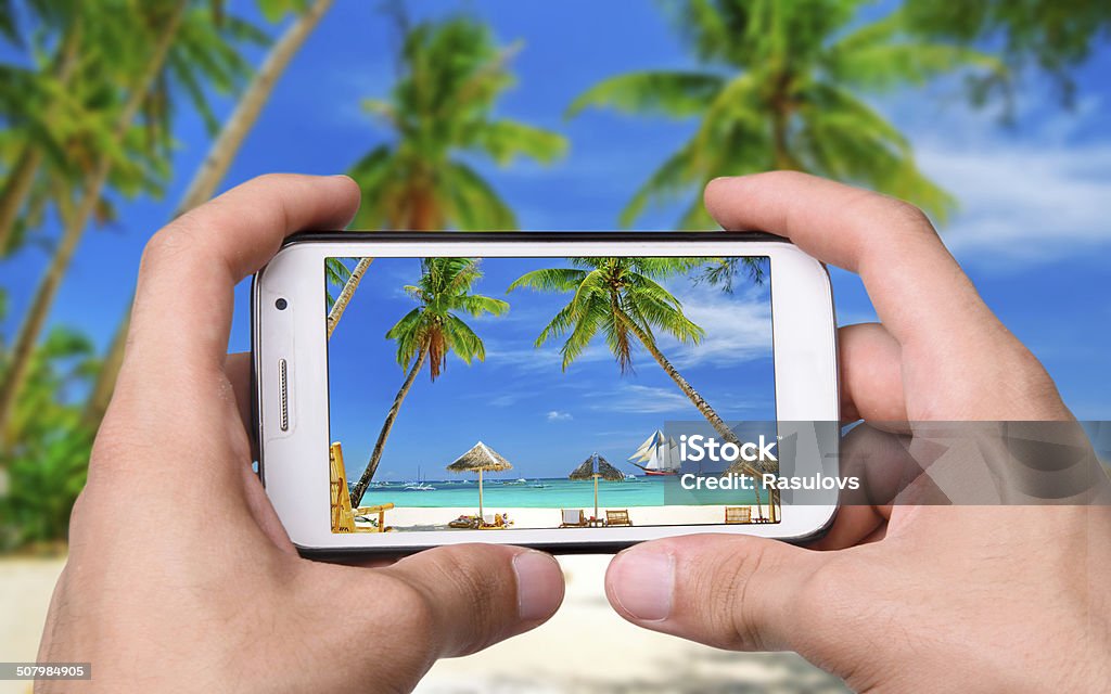 photo beach Hands taking photo beach with smartphone Backgrounds Stock Photo
