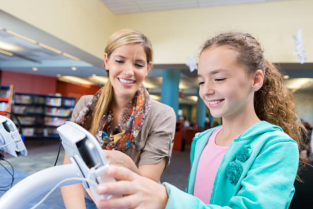 istock Girl using touch screen device to listen to library audiobook 507994202