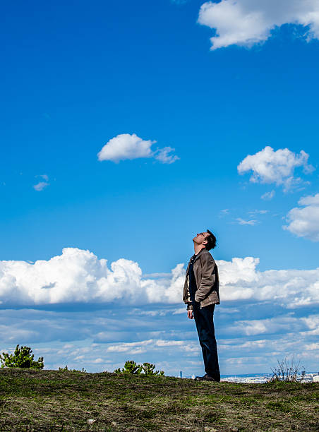 Man standing on hill looking into the sky
