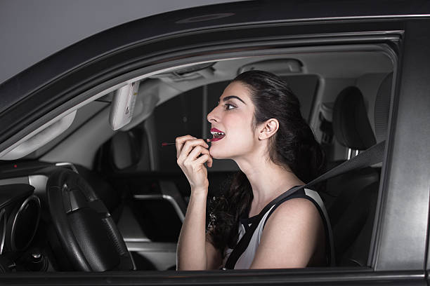 istock woman making up her lips with red lipstick in car 508000768