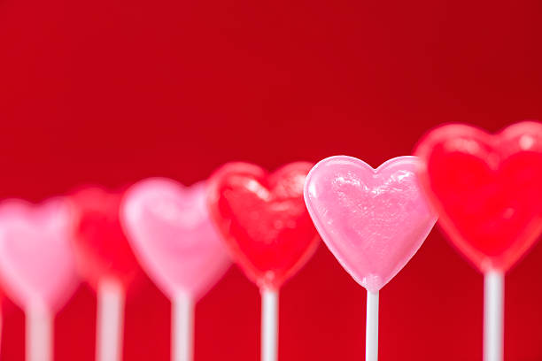 istock Row of heart shaped lollipops on red background 508002078