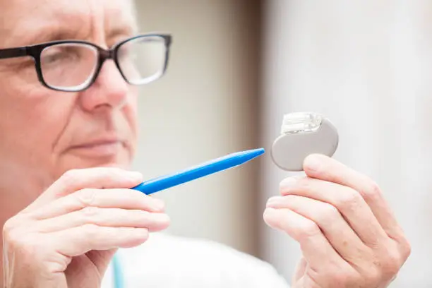 Photo of Mature doctor pointing at a cardial pacemaker