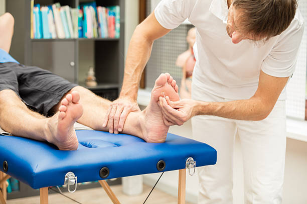 Doctor testing sensibility of foot stock photo