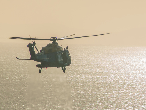 South Stack, Holyhead, North Wales - January 9, 2013: A Griffin SARTU Helicopter practicing off the Anglesey coast on a bright sunny January day. HRH Prince William was based at RAF Valley at this time and once the presence of a photographer in the area was noticed the helicopter departed very quickly.